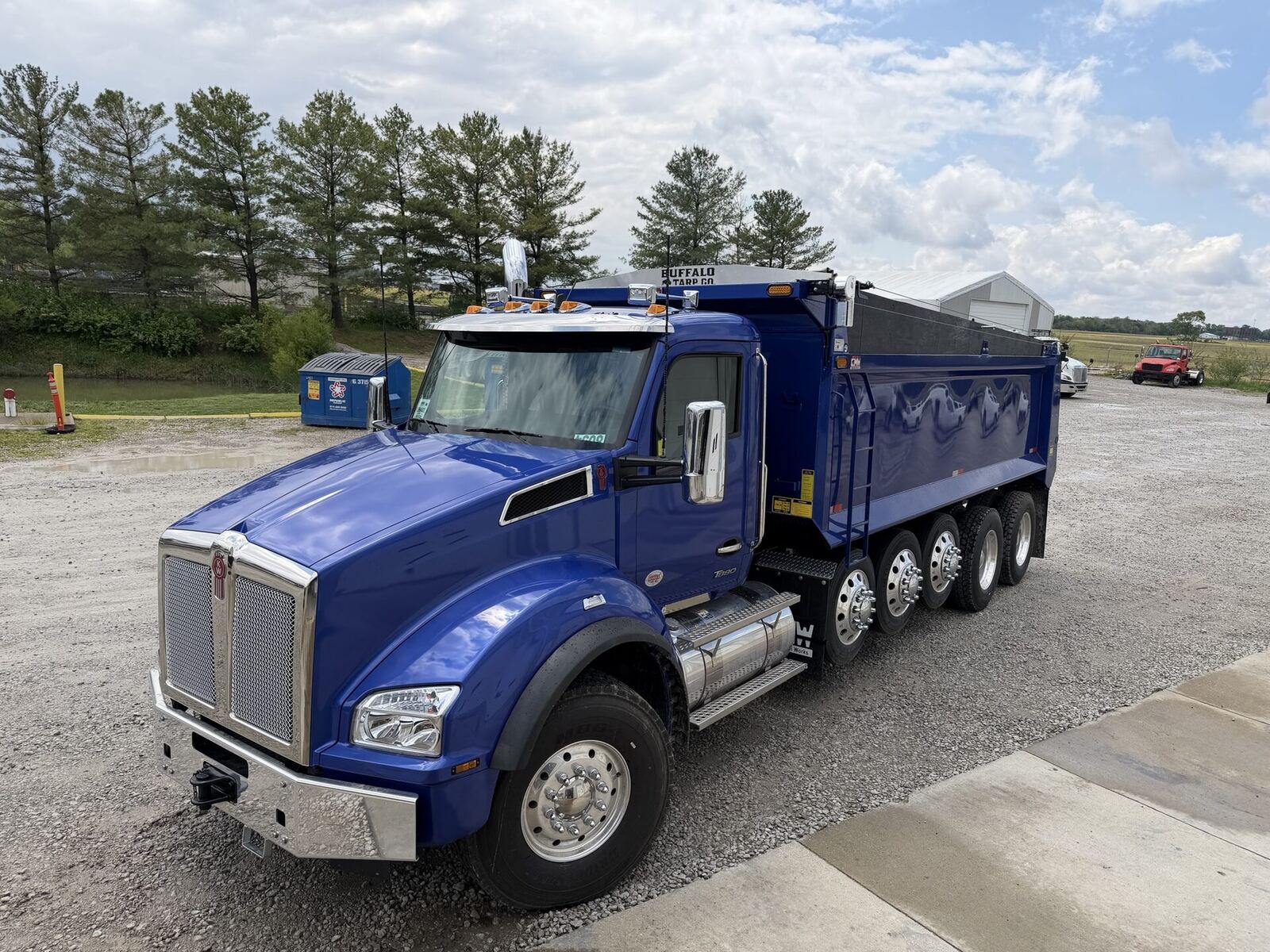 Kenworth dump truck equipped with a Buffalo Tarp Co. system, parked under a wide sky in rural Ohio.